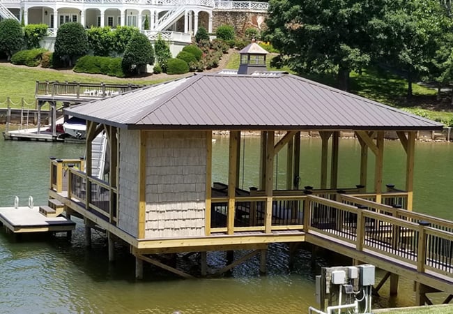 Backside of a stationary dock with a slide showing attached boardwalk to the shore